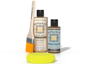 A Retique It wood restoration kit on a white background, including a bottle of liquid wood primer, a bottle of stain alternative, a yellow sponge, and a wooden brush.