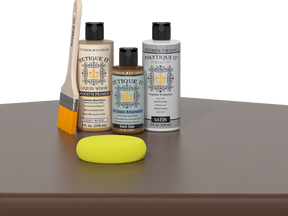 Retique It® Light Wood Wood’n Primer with Dark Oak Gel Stain Alternative, satin topcoat, brush, and yellow sponge on a tabletop.