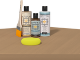 Retique It® Pecan Multipurpose Kit contents with Light Wood Liquid Wood primer, Pecan gel stain alternative, Tripletique matte interior top coat, paintbrush, and yellow sponge displayed on a wood surface.