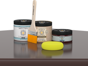 Retique It® Java Multipurpose Kit contents with Liquid Wood primer, Java gel stain alternative, Tripletique gloss interior top coat, paintbrush, and yellow sponge displayed on a dark wood surface.