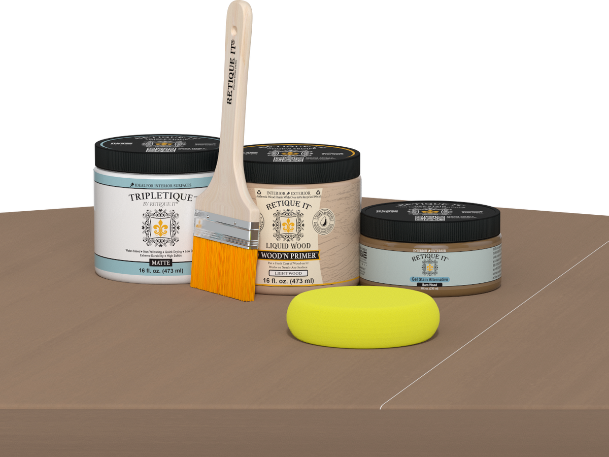 Retique It Barn Wood Kit with Matte Tripletique, Light Wood Wood'n Primer, Barn Wood Gel Stain Alternative, paintbrush, and yellow sponge on a tabletop.