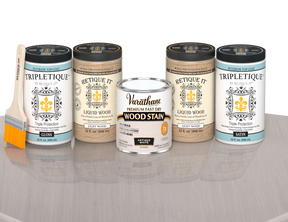 64 oz Retique It Liquid Wood kit with Antique White stain, gloss Tripletique topcoat, and a paintbrush on a matching finished tabletop.