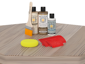 Wood care product set including bottles, a brush, a yellow sponge, and red cloths on a wooden surface.