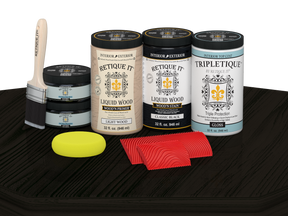 Retique It Wood'n Finish Kit with four large black stain bottles and a glossy finish on a wood tabletop surface.