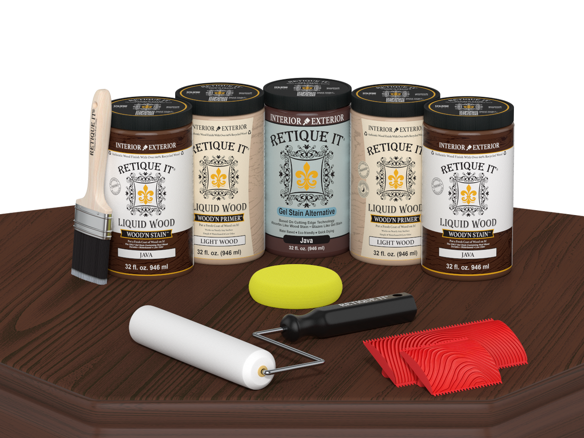 Retique It Java Wood'n Kit featuring Java Liquid Wood stain, Light Wood primer, Java Gel Stain Alternative, paint brush, white roller, yellow sponge, and red graining tools displayed on a dark wood tabletop.