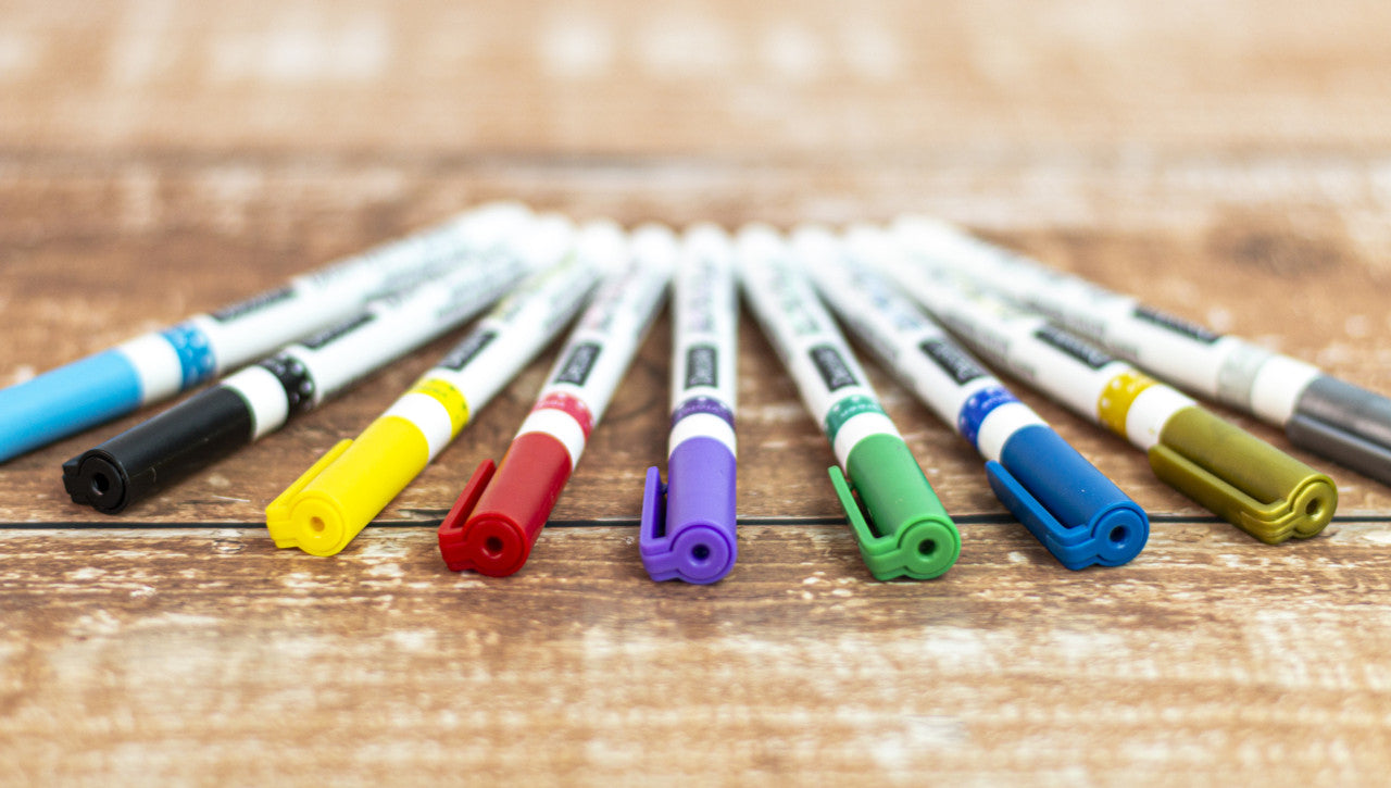Set of six DecoArt glass paint markers with vibrant ink for decorating glass surfaces and creating colorful designs.