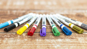 Set of six DecoArt glass paint markers with vibrant ink for decorating glass surfaces and creating colorful designs.