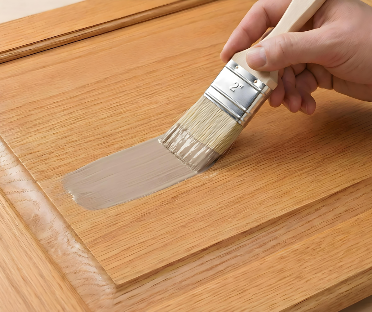 Retique It® Light Wood Kit primer being brushed onto a wood cabinet door.